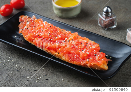 Traditional Spanish breakfast. Tostada with different toppings on a dark background 91509640