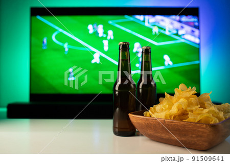 Beer and snacks set on football match tv background Beer and snacks set on football match tv background 91509641