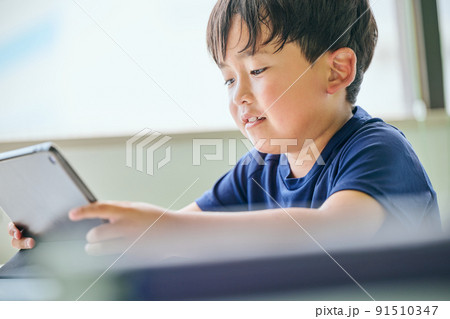 タブレットでオンライン学習をする小学生の男の子 タブレットでオンライン学習をする小学生の男の子 91510347