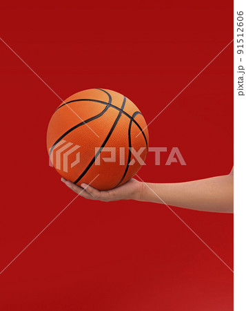 Hands and basketball isolated on red background 91512606