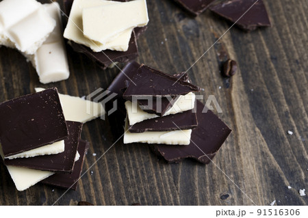 broken into pieces tiles of white and milk and dark chocolate 91516306