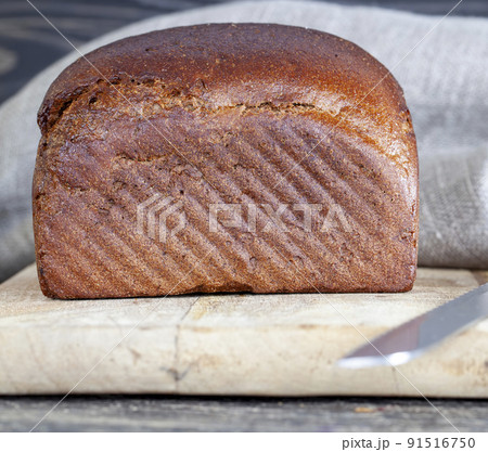 a square rye loaf of bread on a cutting board a square rye loaf of bread on a cutting board 91516750
