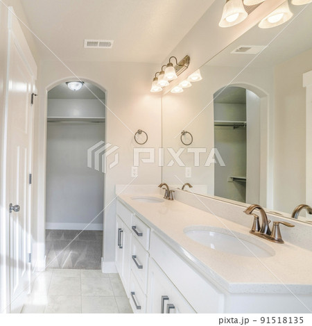 Square frame Interior of a white bathroom with shower with glass wall, sink and empty closet 91518135