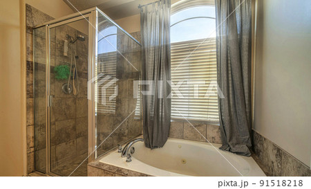 Pano Bathroom interior with round built in bathtub shower stall and warm toned tiles Pano Bathroom interior with round built in bathtub shower stall and warm toned tiles 91518218