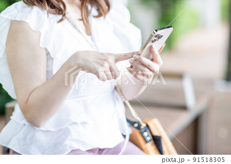 スマホを操作する女性の手元 91518305