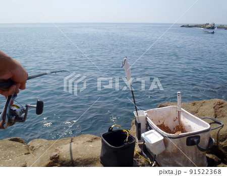 晴天、真夏の沖磯でコマセを使ったウキフカセ釣りに興じる釣り場風景写真。 91522368