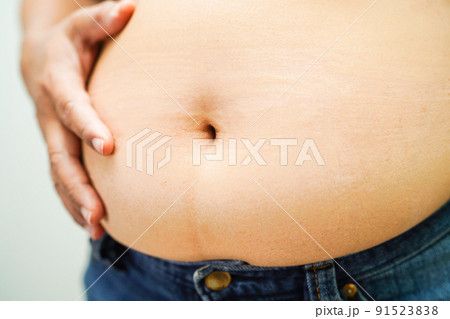 Asian woman show fat belly big size overweight and obesity at office. Asian woman show fat belly big size overweight and obesity at office. 91523838