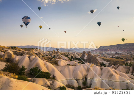 Hot air balloons flying over a volcanic landscape at Cappadocia, Turkey 91525355