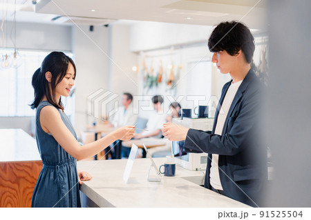 レジでクレジットカード決済をする若い女性 レジでクレジットカード決済をする若い女性 91525504