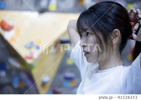 ボルダリングをする前に髪を縛る若い女性 ボルダリングをする前に髪を縛る若い女性 91526353