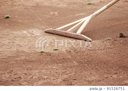 野球場でトンボ・レーキを使い地面をならすグラウンド整備 野球場でトンボ・レーキを使い地面をならすグラウンド整備 91526751