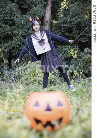 ハロウィン小学生イメージ カボチャの上に乗る女の子 コスプレ レイヤー ハロウィン小学生イメージ カボチャの上に乗る女の子 コスプレ レイヤー 91527620