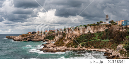 View of lighthouse at seashore against cloudy sky. Beautiful Lighthouse On The Rocks near Sile, Istanbul, Turkey, Black Sea. panorama View of lighthouse at seashore against cloudy sky. Beautiful Lighthouse On The Rocks near Sile, Istanbul, Turkey, Black Sea. panorama 91528364