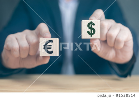 Currency concept. businessman's hands hold two wooden cubes with dollar and euro sign. businessman chooses euro or dollar signs 91528514