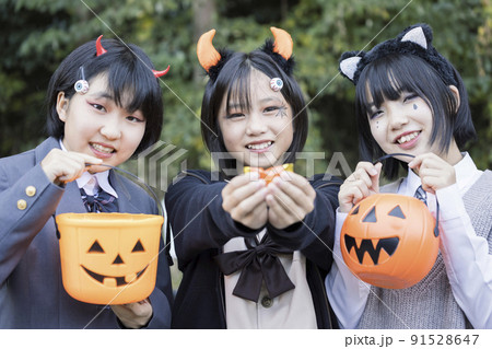 ハロウィン小学生イメージ　お菓子を持つ子供　トリックオアトリート 91528647