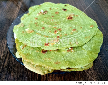 Palak paratha or Indian flat breads made from spinach and served with mango pickle and mint dip, Indian breakfast 91531671