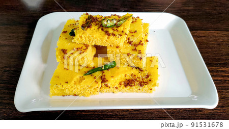Gujarati Khaman Dhokla made using Chana Dal, served with Green chutney, selective focus 91531678