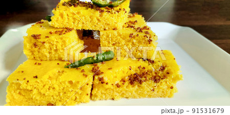 Gujarati Khaman Dhokla made using Chana Dal, served with Green chutney, selective focus 91531679