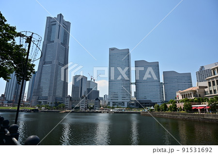 横浜みなとみらい　立ち並ぶ高層ビルと運河に移る高層ビルの姿　広く広がる真夏の青空 91531692