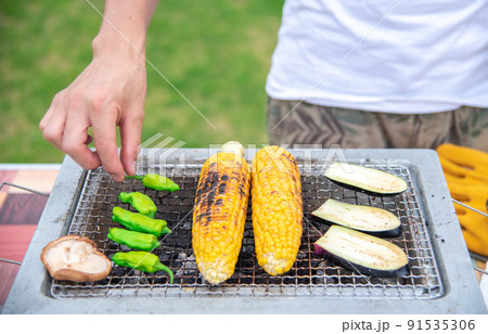 BBQで焼いている男性の手元 91535306