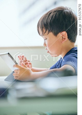 タブレットでオンライン学習をする小学生の男の子 91537970