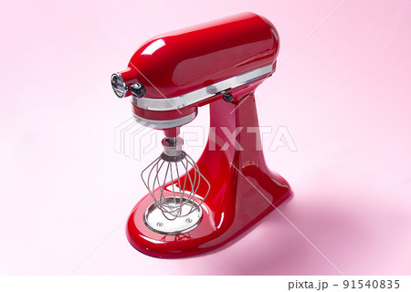 Red kitchen mixer on a pink background. Red kitchen mixer on a pink background. 91540835