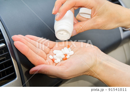 Women in car take anti stress pills. Women taking tablets inside his car. 91541011