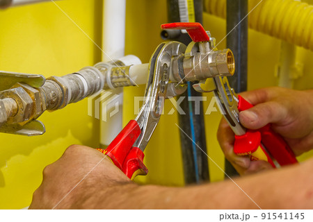 connecting plumbing fittings with keys. The plumber assembles a new water connection to the sink. connecting plumbing fittings with keys. The plumber assembles a new water connection to the sink. 91541145
