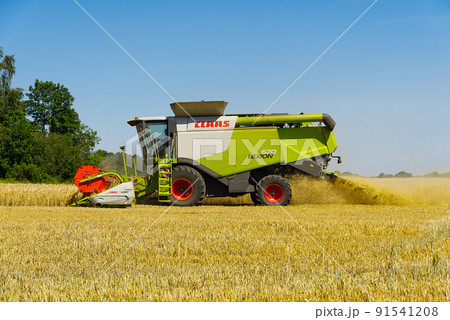 Estonia, Raasiku 18.07.2020 on a sunny summer day, the harvester Claas Lexion 670 harvests wheat or barley. 91541208