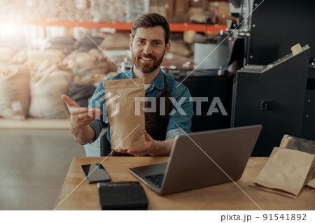 Business owner propose roasted coffee beans in paper bag in coffee factory ready for sale Business owner propose roasted coffee beans in paper bag in coffee factory ready for sale 91541892