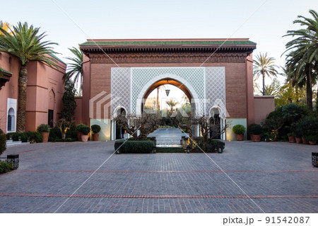 モロッコの街マラケッシュの街並み　歴史的でゴージャスなホテルの入口にある赤茶色の壁とタイル張りの門 91542087