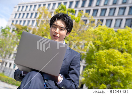 屋外でリモートワークをする男性のポートレート 91543482