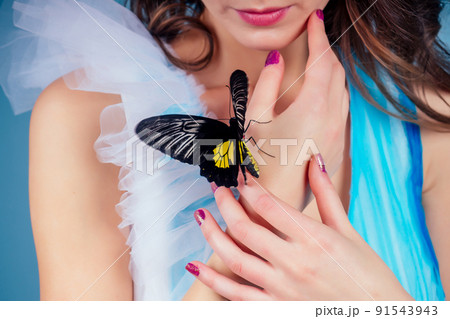 Art photo fashion model shows a bright make-up. Beautiful young sexy woman green eyes and live butterfly yellow black wings.sensual close-up portrait perfect skin, professional makeup and hairstyle 91543943