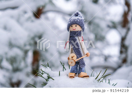 Angel gnome in scarf and knitted hat skiing on snowy fir branch Elf toy on skis in snowy landscape Copy space for text. New year and Merry christmas greeting card background. Ski winter resort 91544219