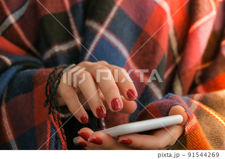 Stylish red female nails holding mobile phone. Smartphone technology. Social media. Modern Beautiful manicure. Autumn winter nail design concept of beauty treatment. Gel nails. Skin care. Stylish red female nails holding mobile phone. Smartphone technology. Social media. Modern Beautiful manicure. Autumn winter nail design concept of beauty treatment. Gel nails. Skin care. 91544269