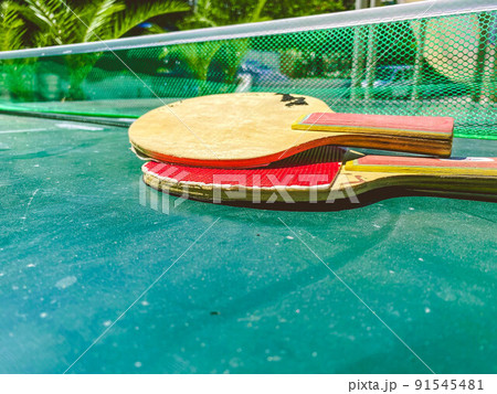 table tennis. small red rackets lie on a table made of green material. doubles game with a small ball. active leisure, fun pastime in a hotel in a resort table tennis. small red rackets lie on a table made of green material. doubles game with a small ball. active leisure, fun pastime in a hotel in a resort 91545481