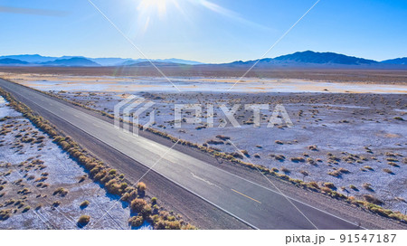 Tourist highway road through flat desert plains with mountains Tourist highway road through flat desert plains with mountains 91547187