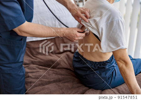 Close up of doctor listening to old woman's patient breathing, using stethoscope Close up of doctor listening to old woman's patient breathing, using stethoscope 91547851