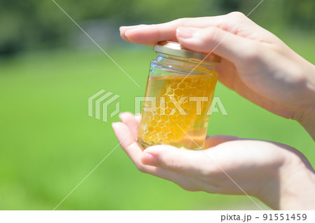 手に持った瓶詰めのハチミツ 手に持った瓶詰めのハチミツ 91551459