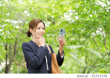 スマホを持つ女性　新緑 91551548