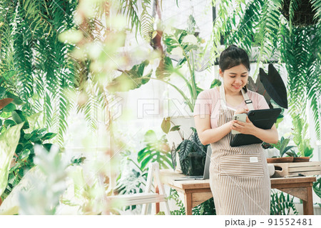 Young woman plant shop owner is checking customer order from website Young woman plant shop owner is checking customer order from website 91552481