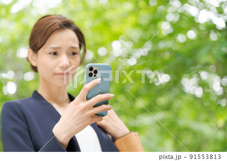 スマホを持つ女性 新緑 スマホを持つ女性 新緑 91553813