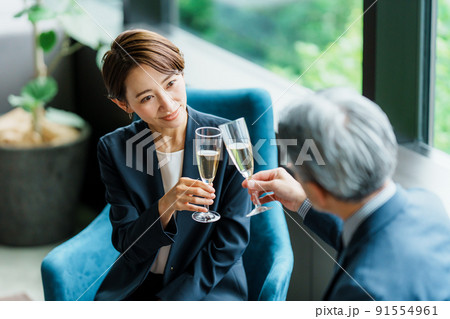 ラウンジでシャンパンを飲むシニア経営者と秘書 91554961