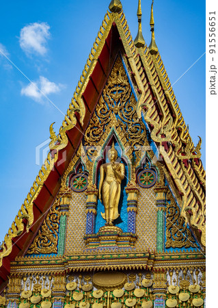 Buddha statue stands on the front of the temple building with beautiful Thai Art pattern style in the open sky day. Buddha statue stands on the front of the temple building with beautiful Thai Art pattern style in the open sky day. 91556651