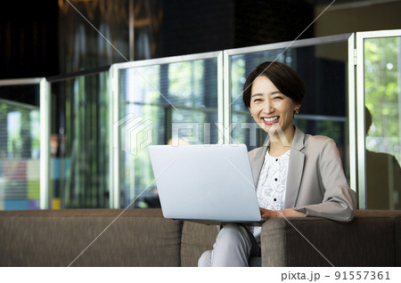 ビジネス　女性　オフィス　ノートパソコン　笑顔　カメラ目線 91557361