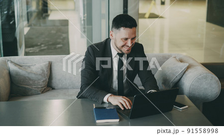Successful businessman using laptop compute in classy cafe during lunch time. He found Successful businessman using laptop compute in classy cafe during lunch time. He found 91558998