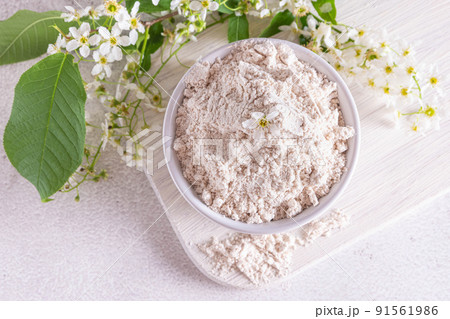 Birdcherry flour in a bowl, top view on grey background 91561986