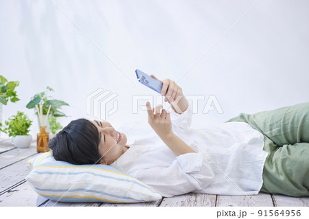 リビングでスマホを見る若い女性 リビングでスマホを見る若い女性 91564956