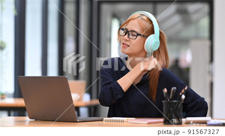 Tired business woman massaging rubbing stiff sore neck tensed muscles, suffering from neck pain, work in incorrect posture Tired business woman massaging rubbing stiff sore neck tensed muscles, suffering from neck pain, work in incorrect posture 91567327