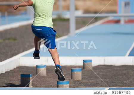 Mud race runners. The chid overcoming the obstacle 91567436